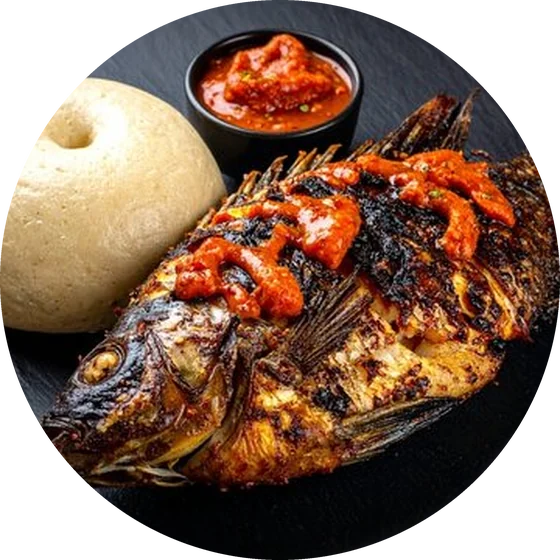 A whole grilled tilapia served with chilli sauce and a side
